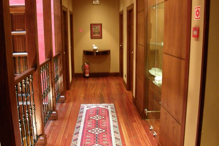 A polished hardwood hallway with a patterned runner rug and timber doors